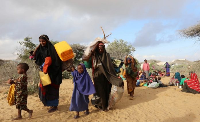 Internally displaced Somalis carry their belongings as they flee from drought stricken regions in Lower Shabelle region before entering makeshift camps in Somalia's capital Mogadishu